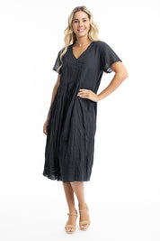 A model wearing the Essentials Organic Cotton Gauze Peak Dress in colour Black (Black), from the front, showing the whole outfit