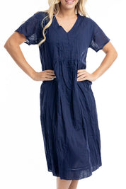 A model wearing the Essentials Organic Cotton Gauze Peak Dress in colour Navy (Blue), from the front, cropped image