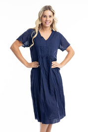 A model wearing the Essentials Organic Cotton Gauze Peak Dress in colour Navy (Blue), from the front, cropped image