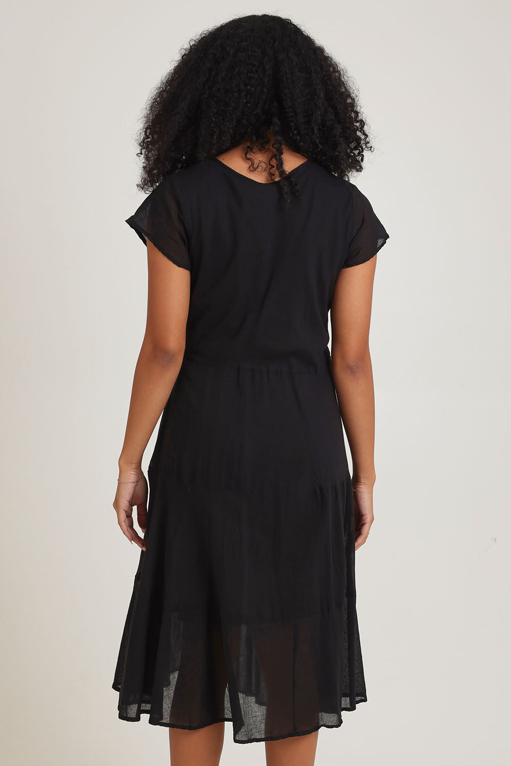 Model Ziara wearing size 10 of the Essentials Bias Pockets Cotton Dress in colour Black (Black), from the back