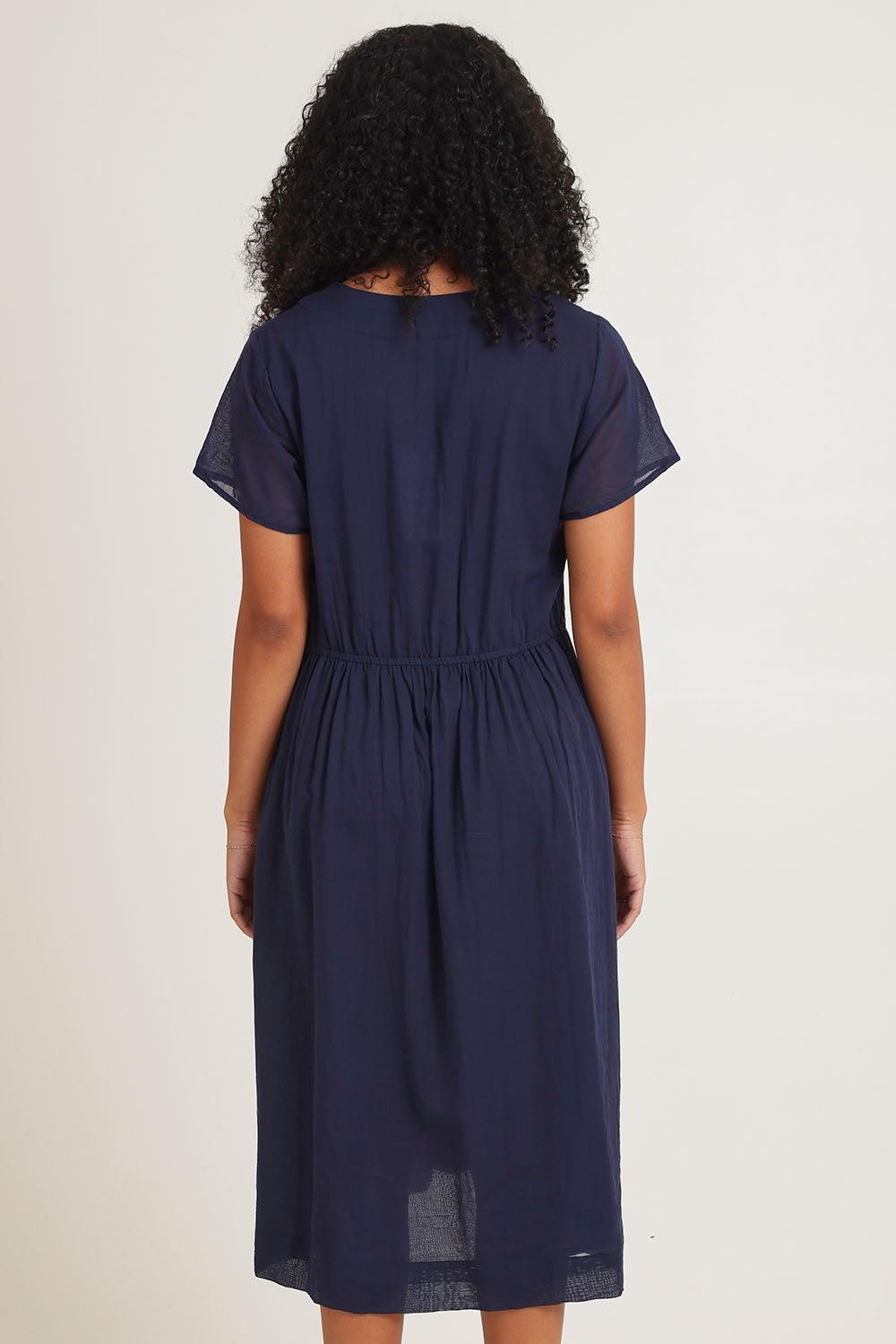 Model Ziara wearing size 10 of the Essentials Tie Waist Cotton Dress in colour Navy (Blue), from the back