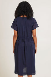 Model Ziara wearing size 10 of the Essentials Tie Waist Cotton Dress in colour Navy (Blue), from the back