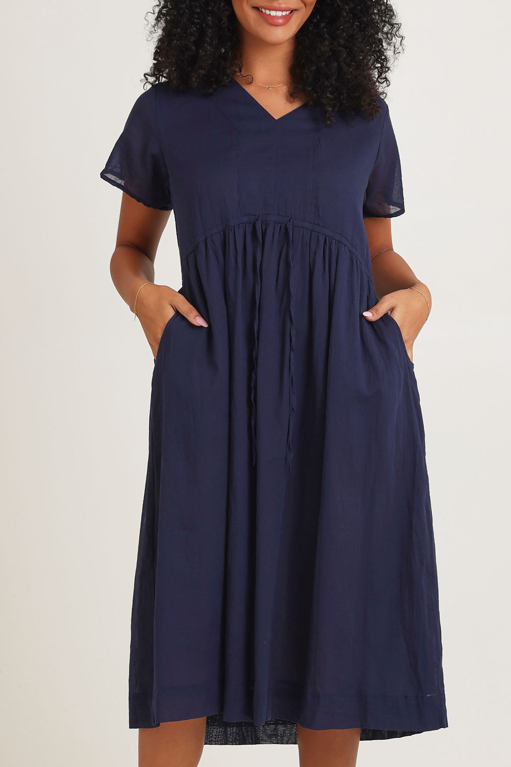 Model Ziara wearing size 10 of the Essentials Tie Waist Cotton Dress in colour Navy (Blue), from the front, cropped image