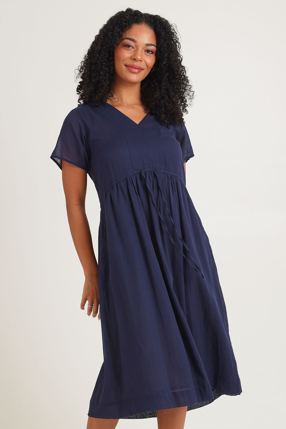Model Ziara wearing size 10 of the Essentials Tie Waist Cotton Dress in colour Navy (Blue), from the front, cropped image