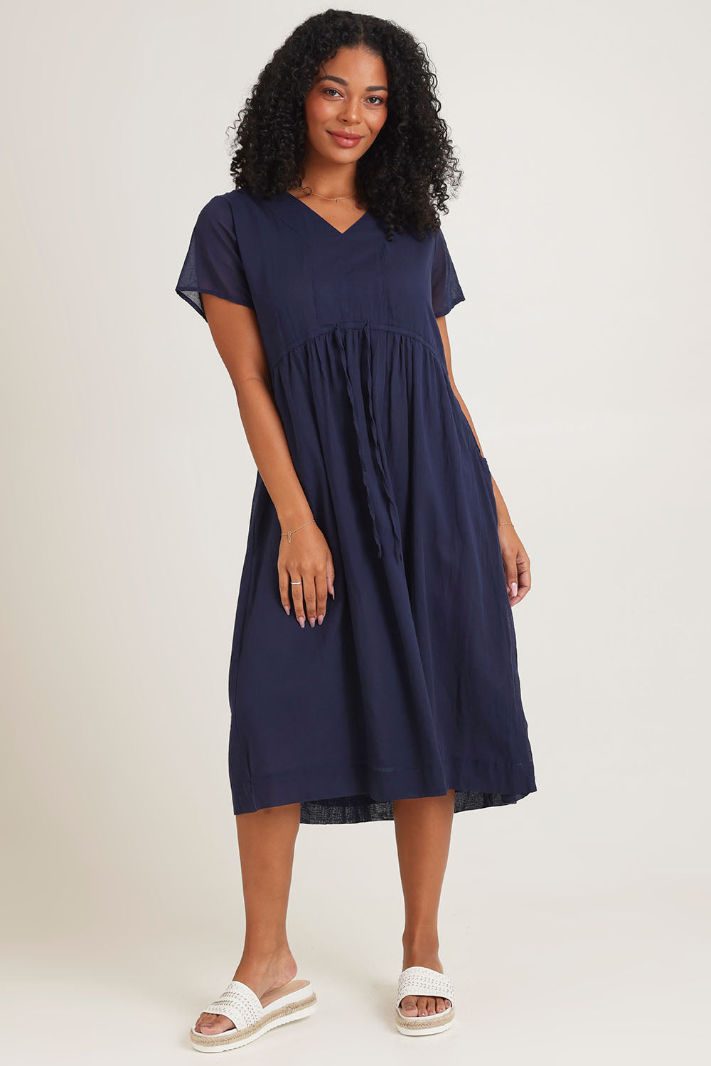 Model Ziara wearing size 10 of the Essentials Tie Waist Cotton Dress in colour Navy (Blue), from the front, showing the whole outfit