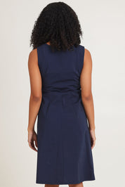 Model Ziara wearing size 10 of the Essentials Pleated Cotton Dress in colour Navy (Blue), from the back