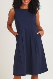 Model Ziara wearing size 10 of the Essentials Pleated Cotton Dress in colour Navy (Blue), from the front, cropped image