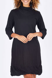Model Summer wearing size 10 of the Turtleneck Dress in colour Black (Black), from the front, cropped image