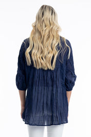 A model wearing the Essentials Organic Cotton Gauze Long Pleated Top in colour Navy (Blue), from the back