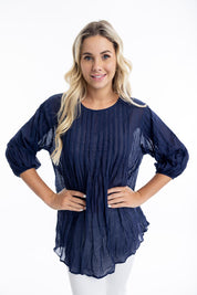 A model wearing the Essentials Organic Cotton Gauze Long Pleated Top in colour Navy (Blue), from the front, cropped image