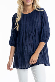A model wearing the Essentials Organic Cotton Gauze Long Pleated Top in colour Navy (Blue), from the front, cropped image