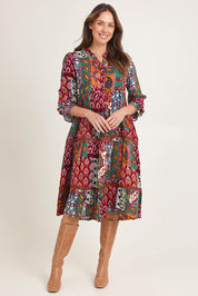 Model Madeline wearing size 10 of the Layers Dress in colour Prato (Red), from the front, showing the whole outfit