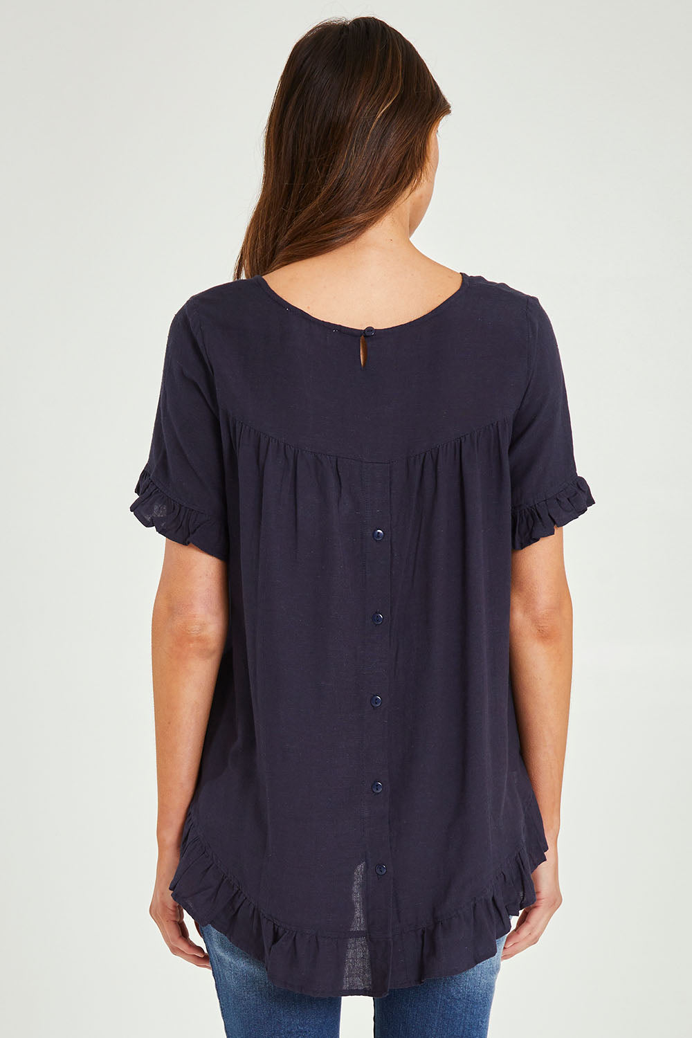 Model Madeline wearing size 10 of the Essentials Linen Blend Frill Top in colour Navy (Blue), from the back