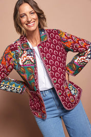 Model Riina wearing size 10 of the Reversible Jacket in colour Prato (Red), from the front, cropped image