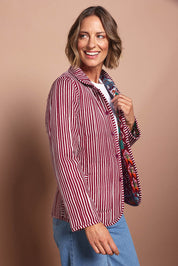 Model Riina wearing size 10 of the Reversible Jacket in colour Prato (Red), from the front, cropped image