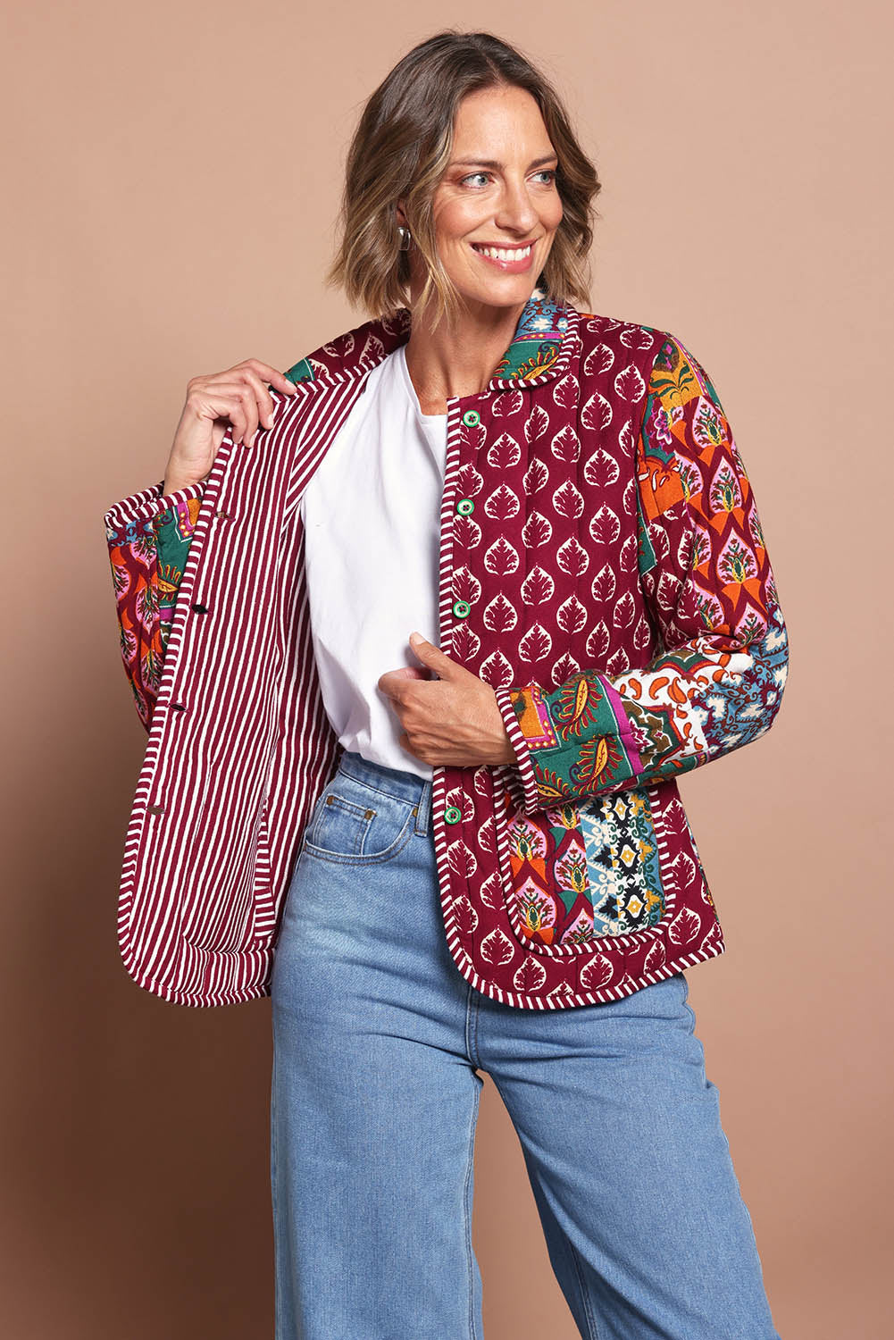 Model Riina wearing size 10 of the Reversible Jacket in colour Prato (Red), from the front, cropped image
