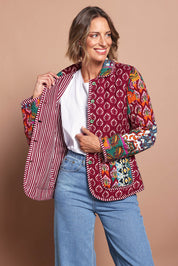 Model Riina wearing size 10 of the Reversible Jacket in colour Prato (Red), from the front, cropped image