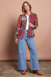 Model Riina wearing size 10 of the Reversible Jacket in colour Prato (Red), from the front, showing the whole outfit