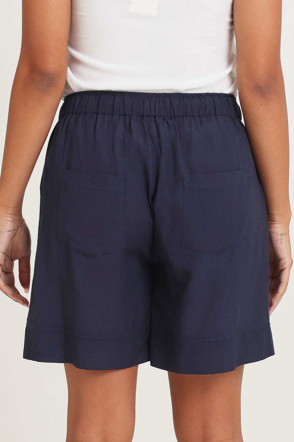 Model Ziara wearing size 10 of the Essentials Linen Blend Shorts in colour Navy (Blue), from the back