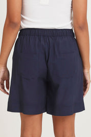 Model Ziara wearing size 10 of the Essentials Linen Blend Shorts in colour Navy (Blue), from the back