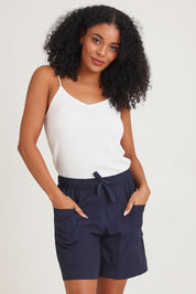 Model Ziara wearing size 10 of the Essentials Linen Blend Shorts in colour Navy (Blue), from the front, cropped image