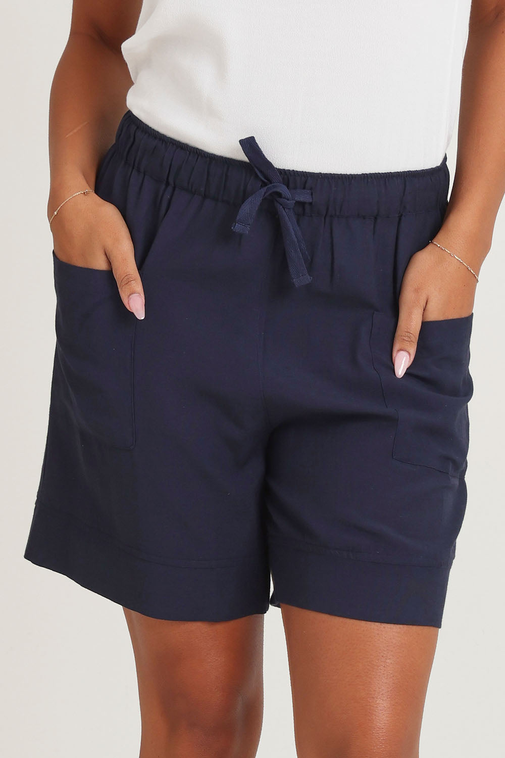 Model Ziara wearing size 10 of the Essentials Linen Blend Shorts in colour Navy (Blue), from the front, cropped image