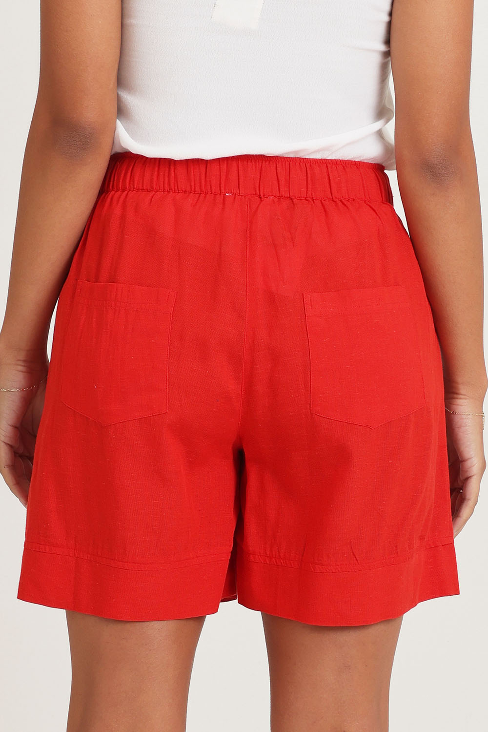 Model Ziara wearing size 10 of the Essentials Linen Blend Shorts in colour Red (Red), from the back