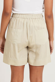 Model Ziara wearing size 10 of the Essentials Linen Blend Shorts in colour Sand, from the back