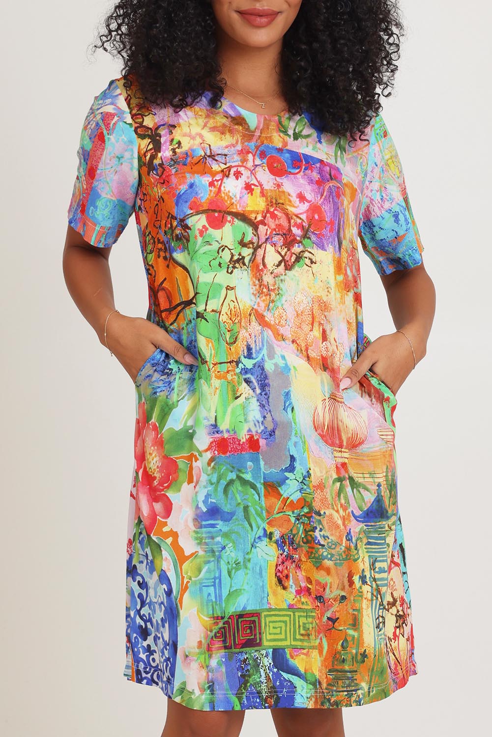 Model Ziara wearing size 10 of the Digital Shift Dress in colour Oriental, from the front, cropped image