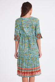 Model Madeline wearing size 10 of the Chania 3/4 Sleeve Layers Dress in colour Print (Green), from the back