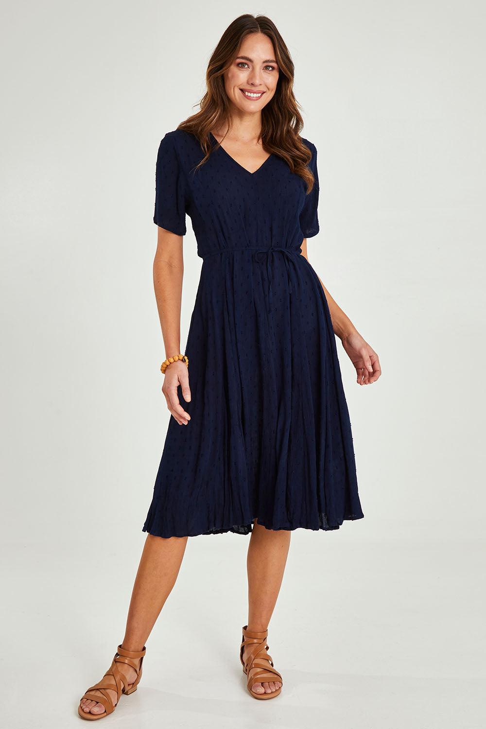 Model Madeline wearing size 10 of the Essentials Godet Short Sleeve Dress in colour Navy (Blue), from the front, showing the whole outfit