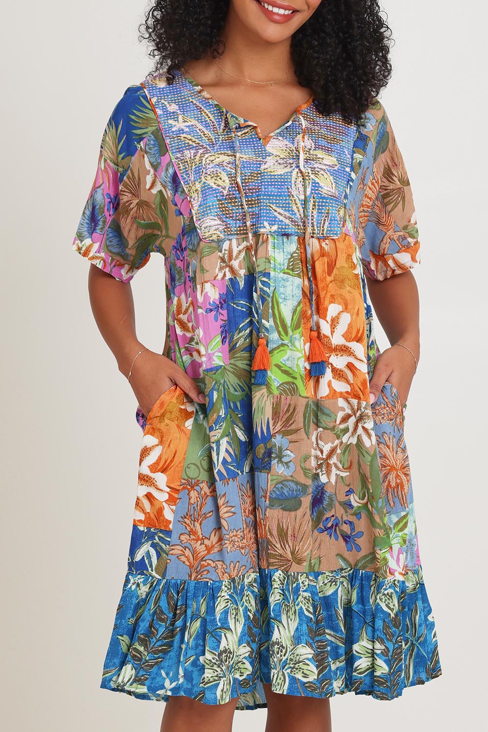 Model Ziara wearing size 10 of the Bib Dress in colour Miramir, from the front, cropped image