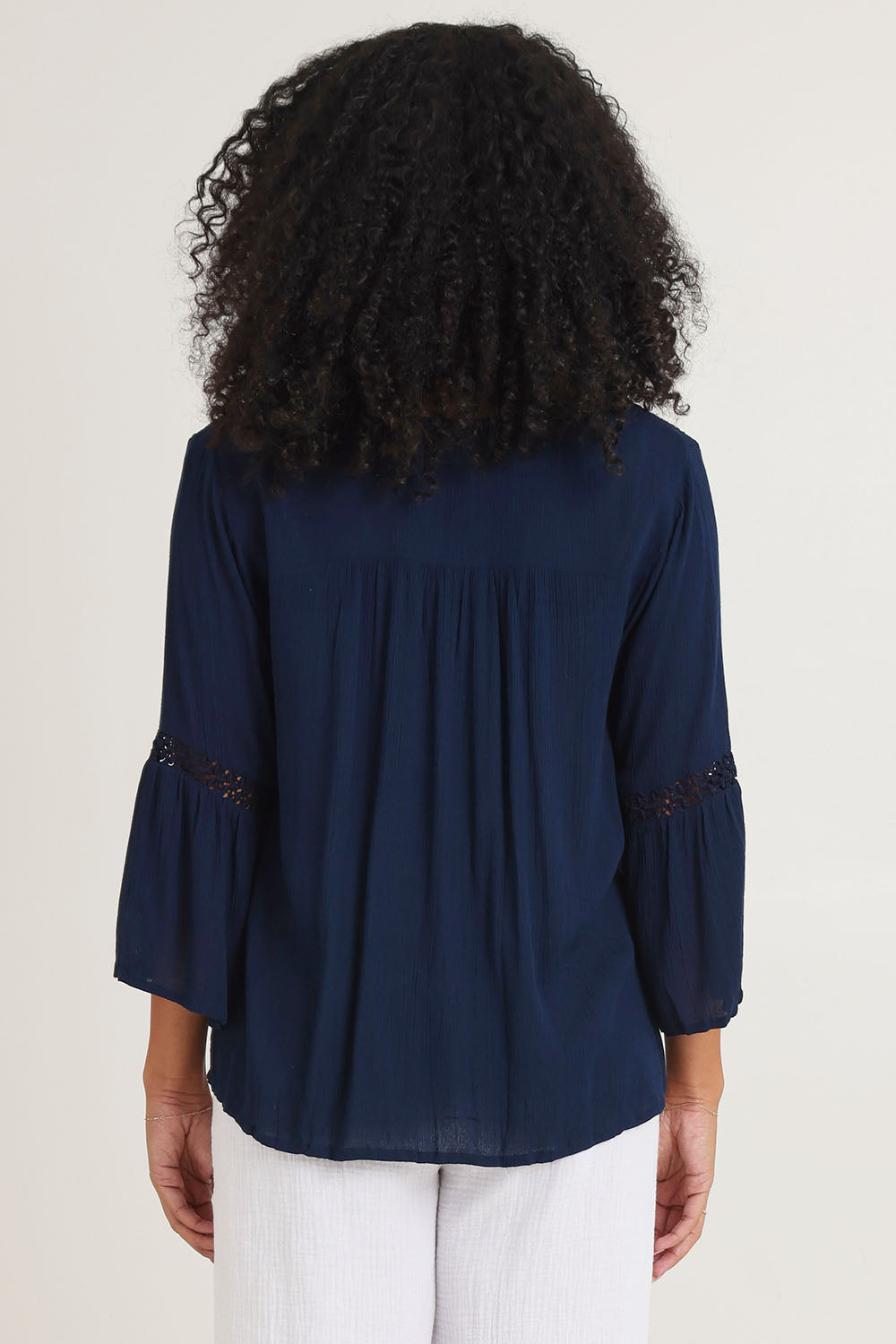 Model Ziara wearing size 10 of the Boho Top in colour Navy (Blue), from the back