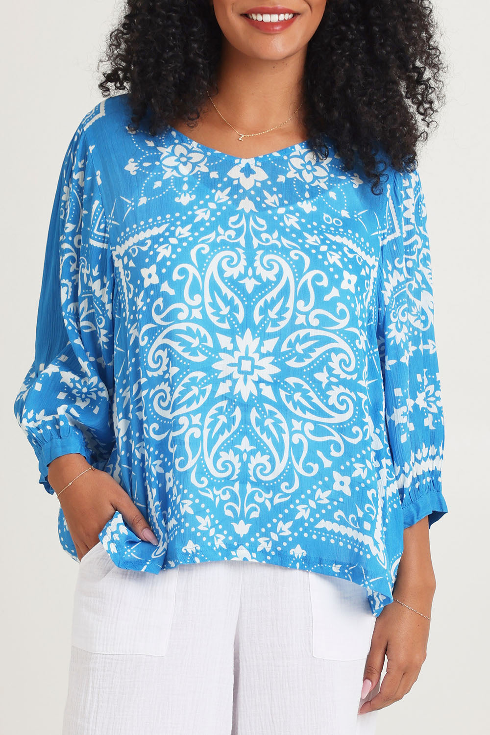 Model Ziara wearing size 10 of the Boho Blouse in colour Bandanabl (Blue), from the front, cropped image