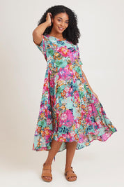 Model Ziara wearing size 10 of the Short Sleeve Godet Dress in colour Selaron, from the front, showing the whole outfit