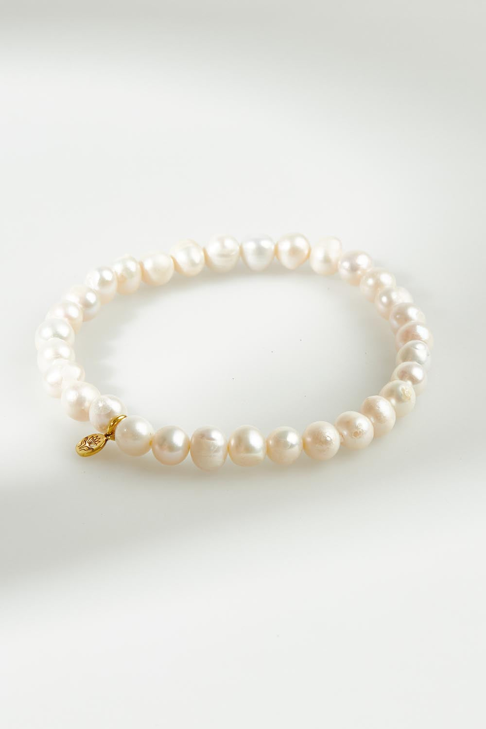 A model wearing the Thick Healing Gem Bracelet in colour Prosperity (White), from the front, showing the whole outfit