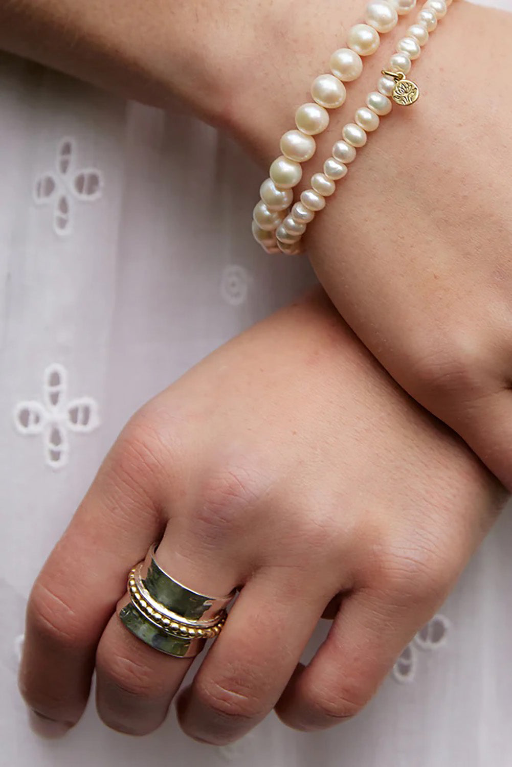 A model wearing the Wide Meditation Spinning Ring in colour Innerlight (Metallics), from the front, showing the whole outfit