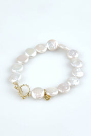 A model wearing the Pearl Fob Bracelet in colour Pearl (White), from the front, showing the whole outfit