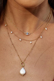 A model wearing the Positano Pearl And Chain Necklace 18K Gold Plated in colour Pearlchain (Metallics), from the front, cropped image