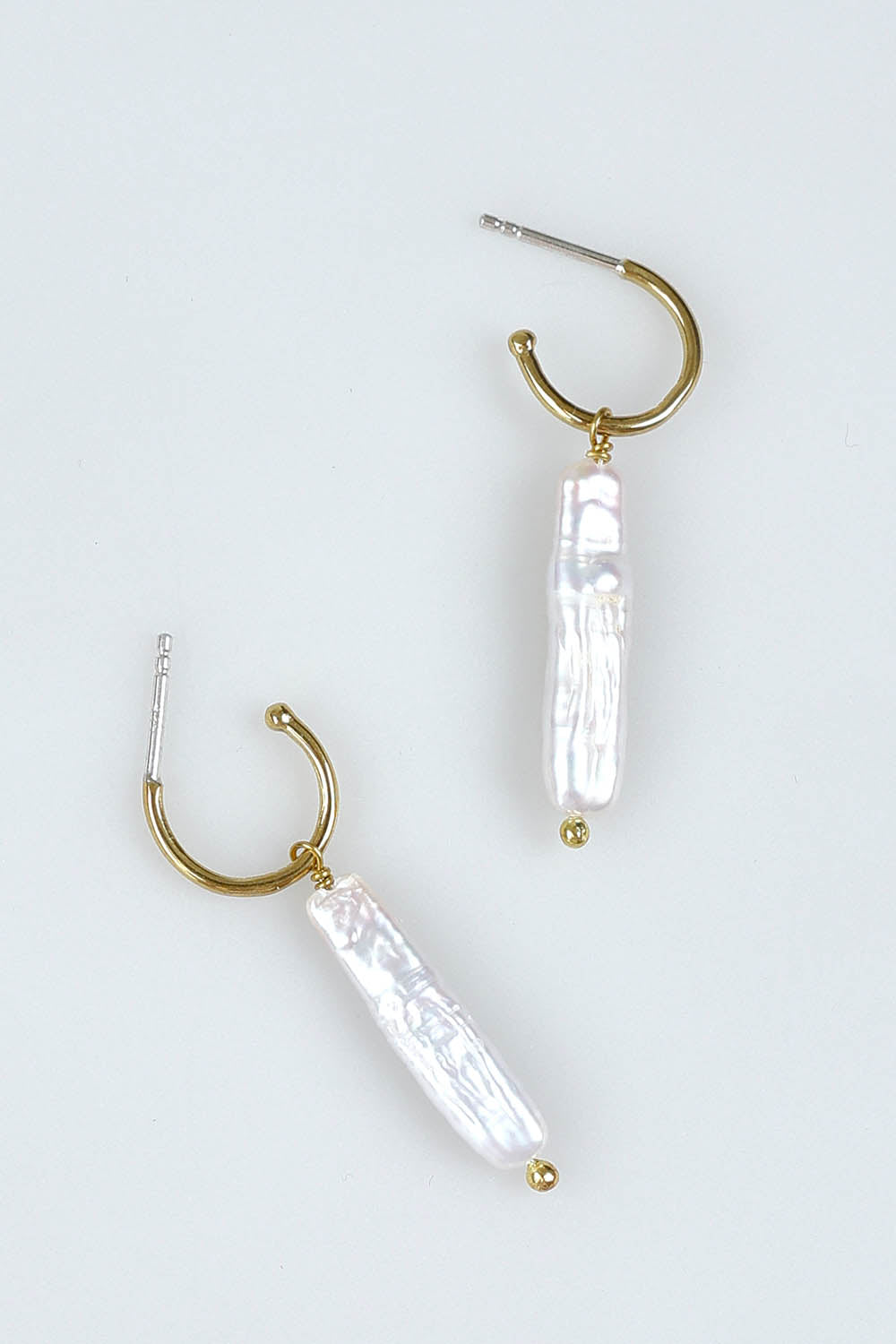 A model wearing the Lunar Pearl Drop Hoop Earrings in colour Goldpearl (Metallics), from the front, showing the whole outfit