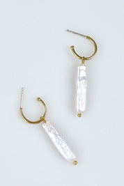 A model wearing the Lunar Pearl Drop Hoop Earrings in colour Goldpearl (Metallics), from the front, showing the whole outfit
