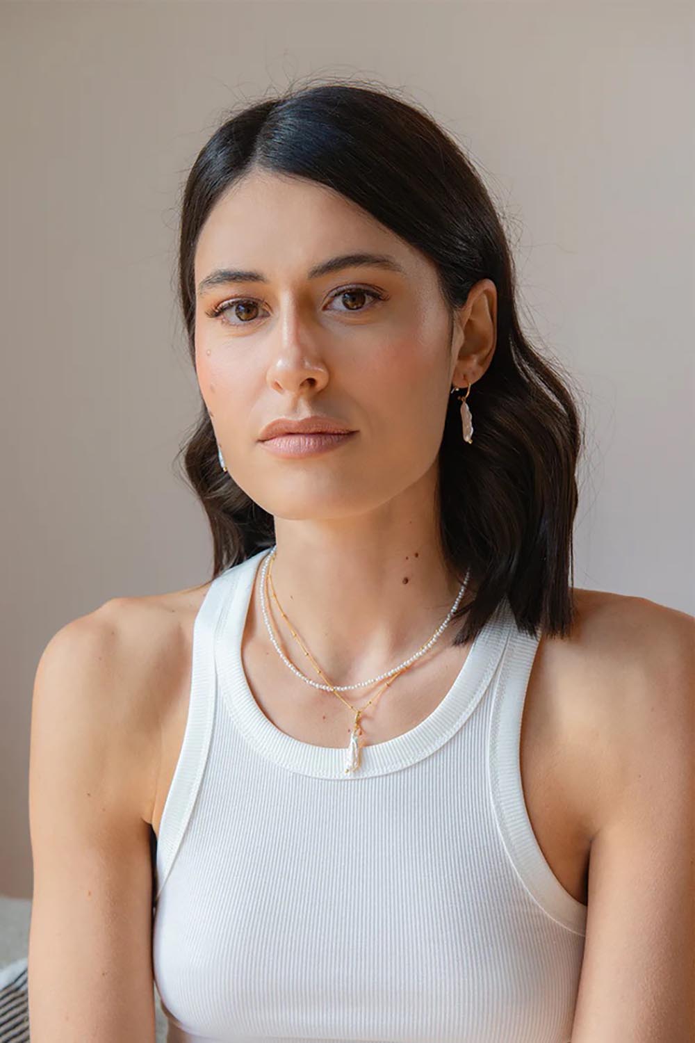 A model wearing the Lunar Pearl Drop Hoop Earrings in colour Goldpearl (Metallics), from the front, showing the whole outfit