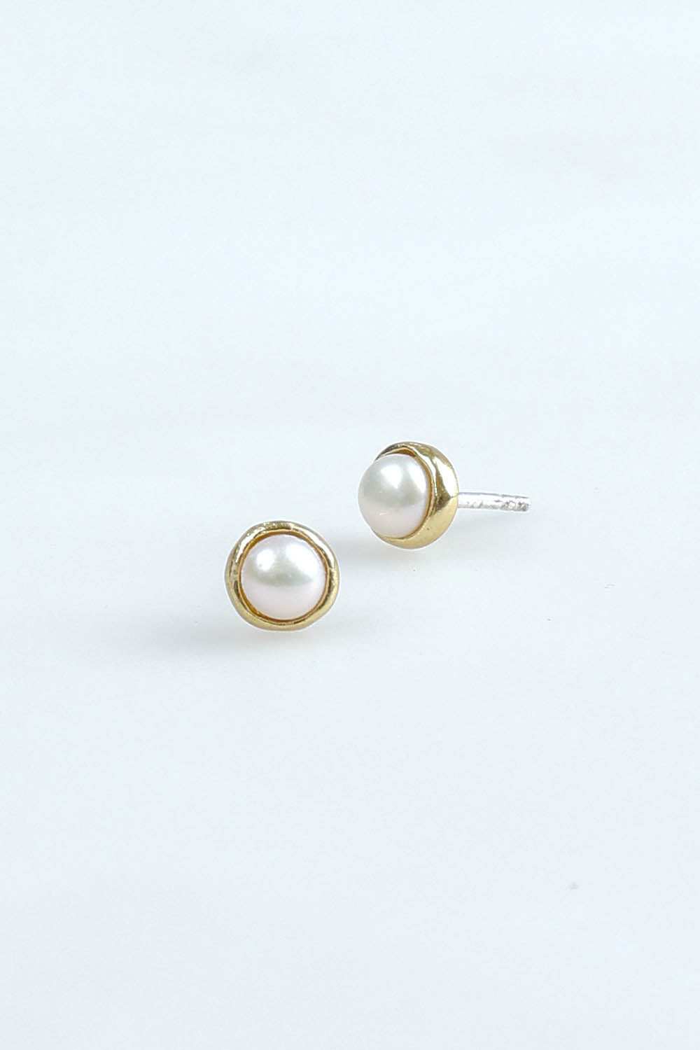 A model wearing the Lunar Pearl Stud Earrings in colour Pearlstud (Metallics), from the front, showing the whole outfit