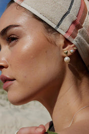 A model wearing the Lunar Pearl Stud Earrings in colour Pearlstud (Metallics), from the front, showing the whole outfit