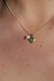 A model wearing the Dreamweaver Necklace in colour Love (Metallics), from the front, showing the whole outfit