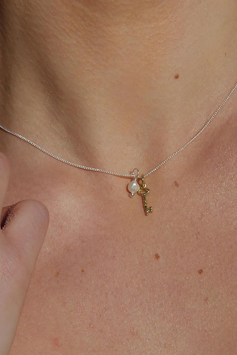 A model wearing the Dreamweaver Necklace in colour Potential (Metallics), from the front, showing the whole outfit