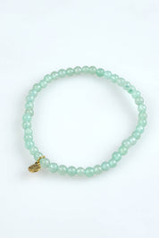 A model wearing the Healing Gem Bracelet in colour Balance (Green), from the front, showing the whole outfit