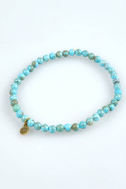 A model wearing the Healing Gem Bracelet in colour Calmness (Blue), from the front, showing the whole outfit
