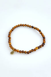 A model wearing the Healing Gem Bracelet in colour Luck, from the front, showing the whole outfit