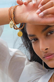 A model wearing the Healing Gem Bracelet in colour Luck, from the front, showing the whole outfit